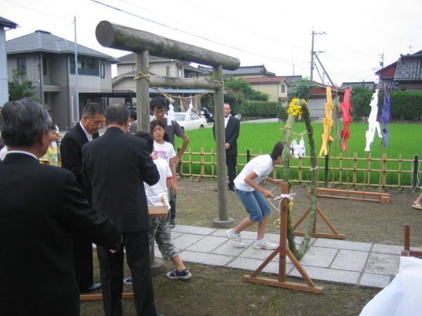 禊場(みそぎば)で茅の輪くぐりに参加する人々の写真