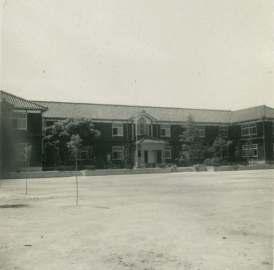校庭の奥に建っている2階建ての早月加積小学校の白黒写真