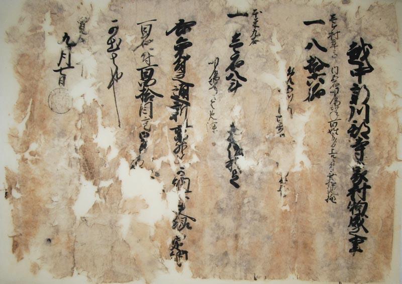 全体的に紙がまだらに変色しており筆書きされた寺家村村御印の画像