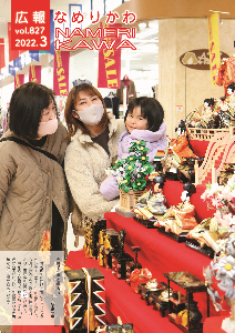 未就学の女児を抱いた母親と祖母の3人連れがエールの入り口に展示された雛段飾りを笑顔で眺める様子を捉えた写真