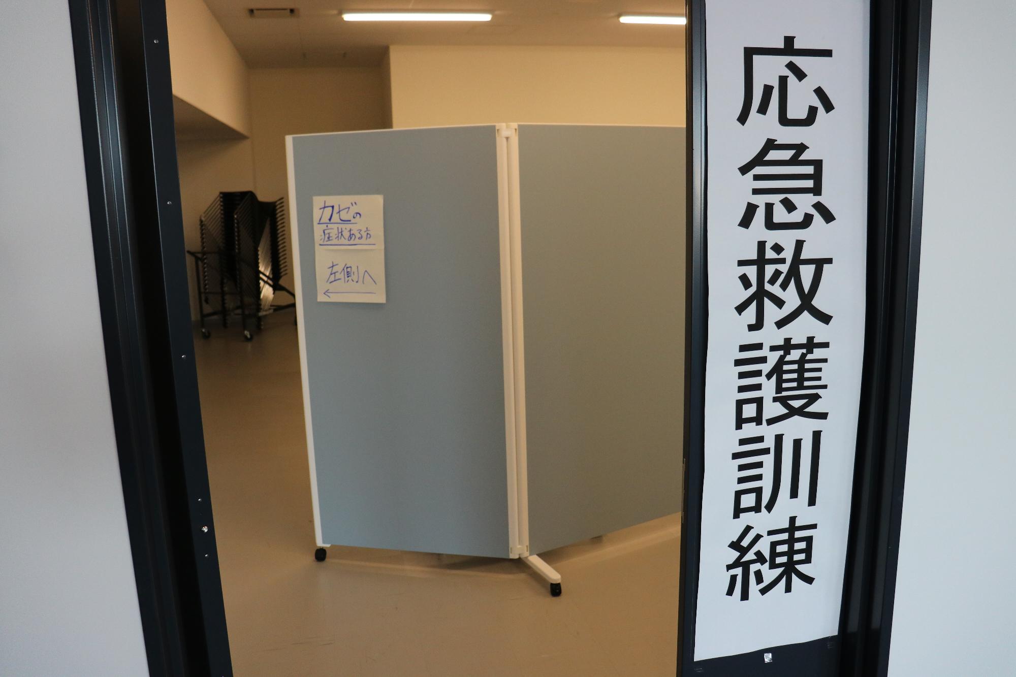 入口横に応急救護訓練と書かれた紙が掲示されている写真