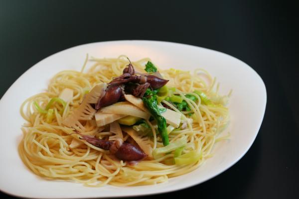 白いお皿に盛り付けられたスパゲッティの上にホタルイカが載っている写真