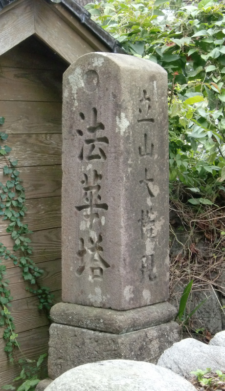 石碑に「法華塔」と文字が刻まれた道しるべの写真