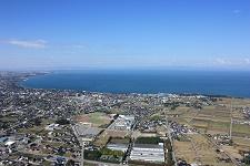 陸地側上空から見た青い富山湾に面する滑川市の写真
